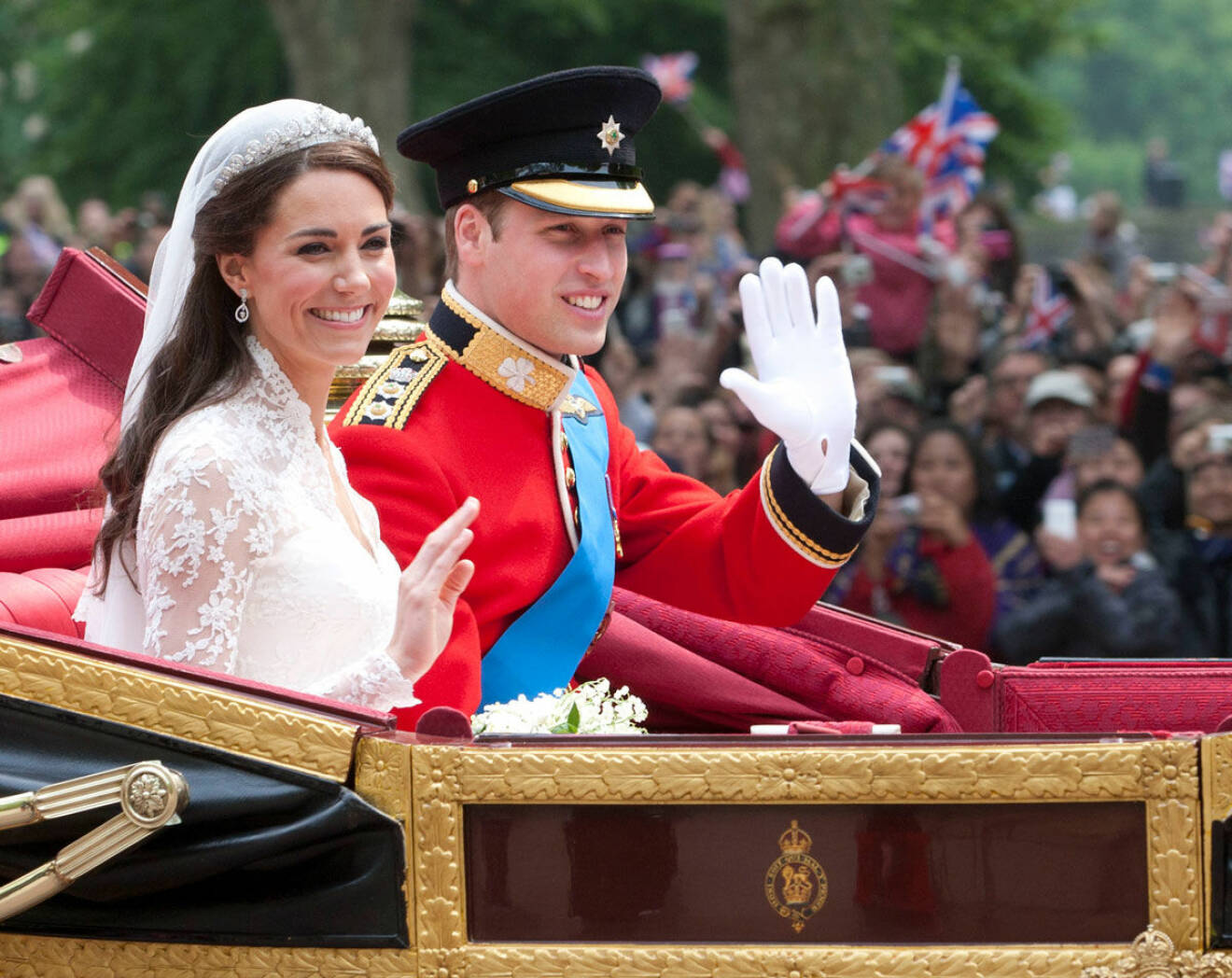 Hertiginnan Kate och prins William ser lyckliga ut. De vinkar till folket. 