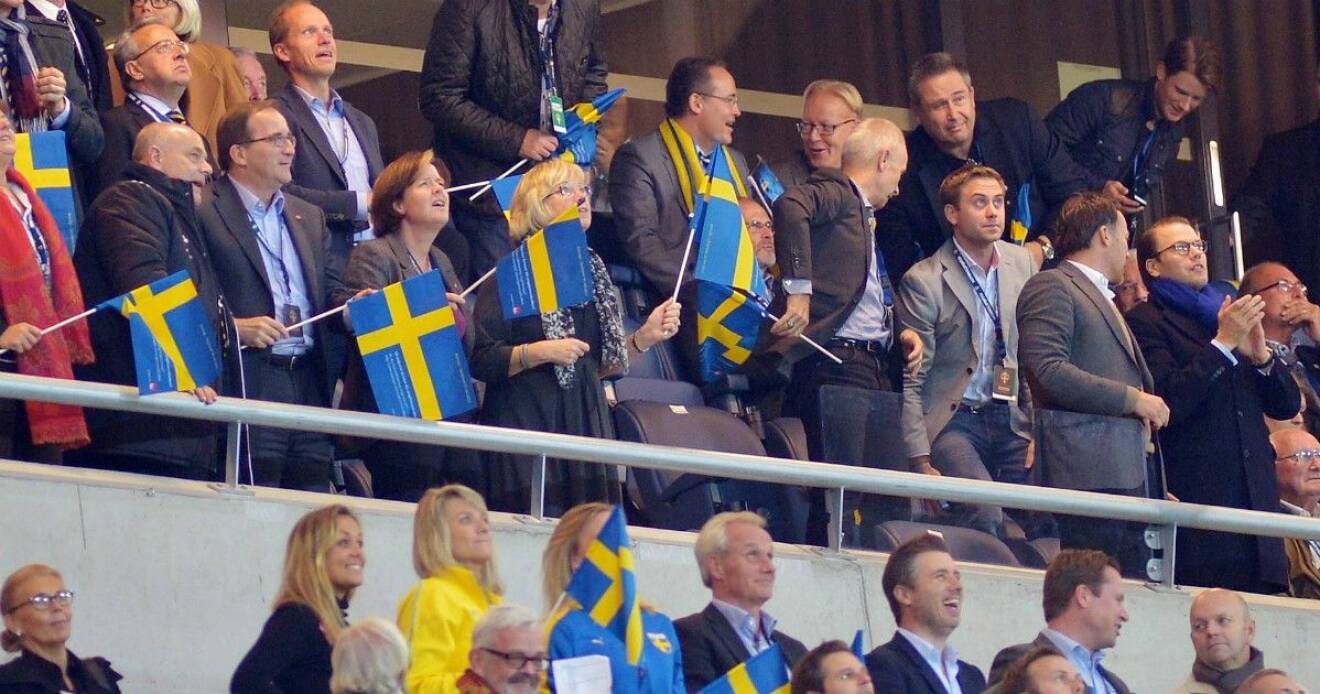 Statsminister Stefan Löfven och prins Daniel hejar fram Sverige från vip-läktaren.