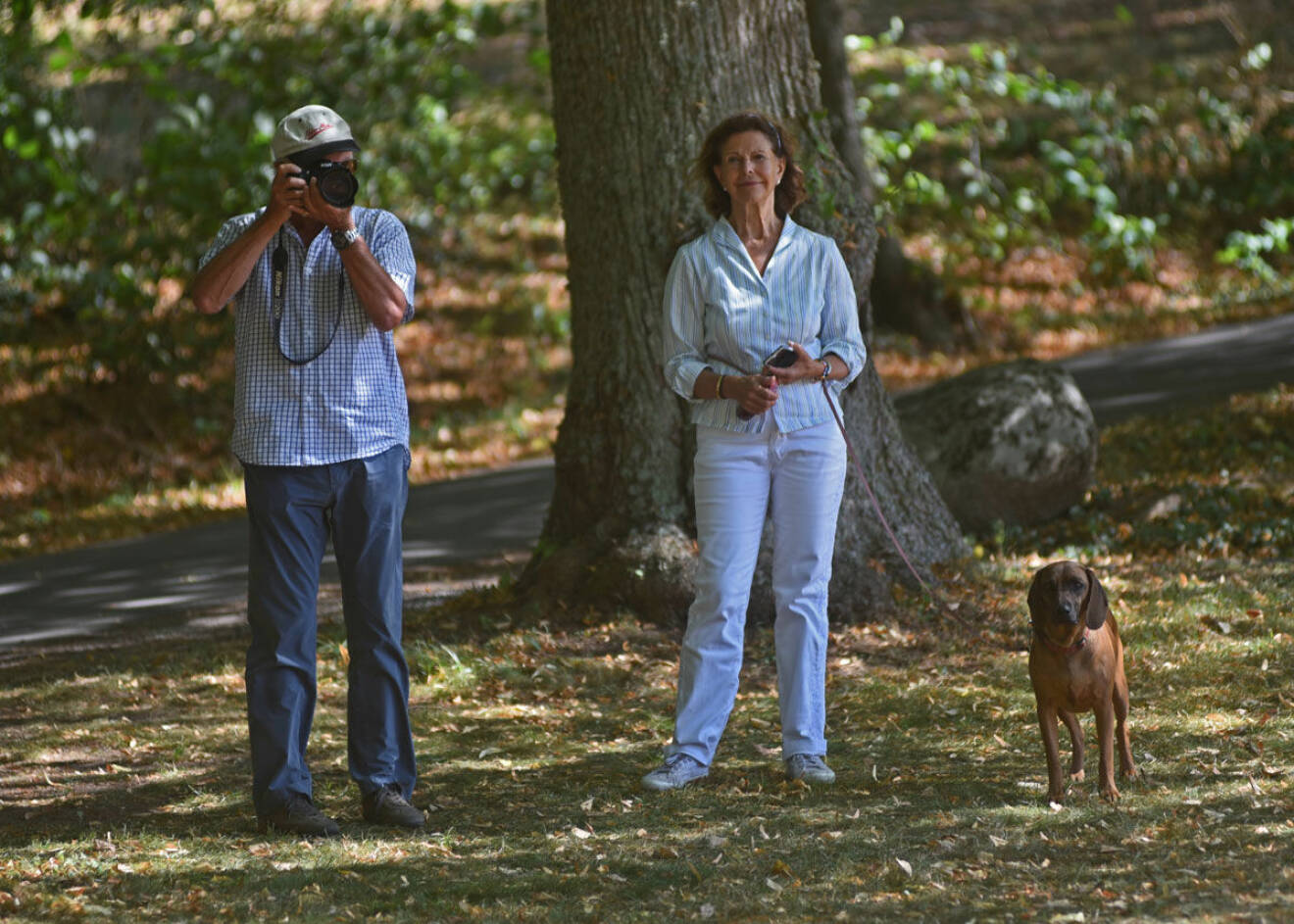 När kungen tog fram sin stora kamera för att fota fick Silvia ta över kopplet på hunden Brandie. 