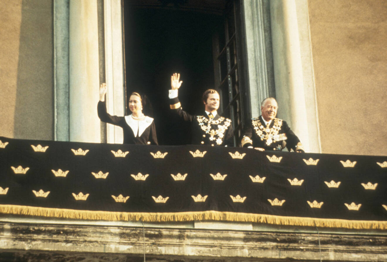 Trontillträdesdagen. Kung Carl Gustaf vinkar från balkongen, och stöttas av prinsessan Christina och prins Bertil. 