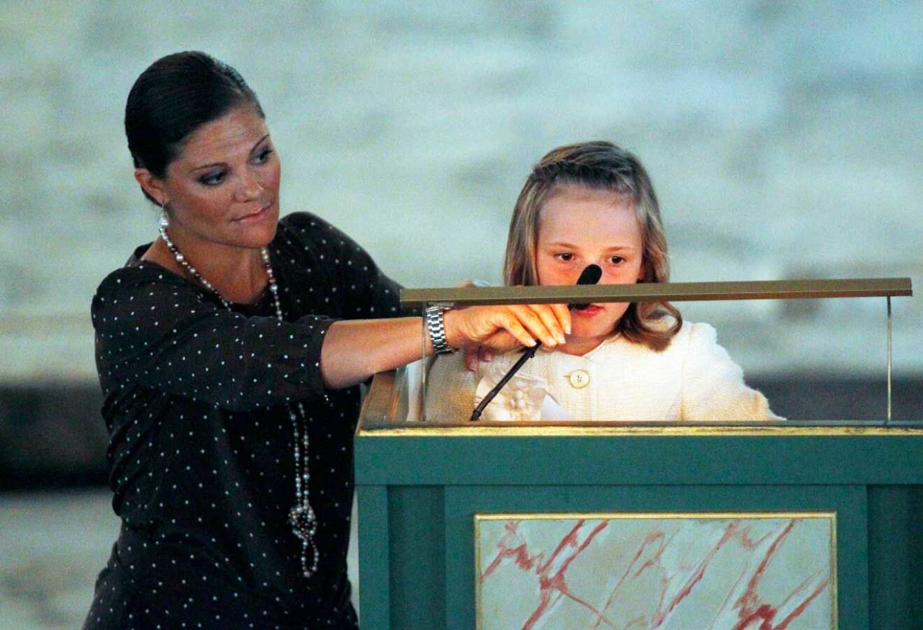 Kronprinsessan Victoria stöttar prinsessan Ingrid Alexandra som ska läsa ur bibeln i kyrkan, sju år gammal. 