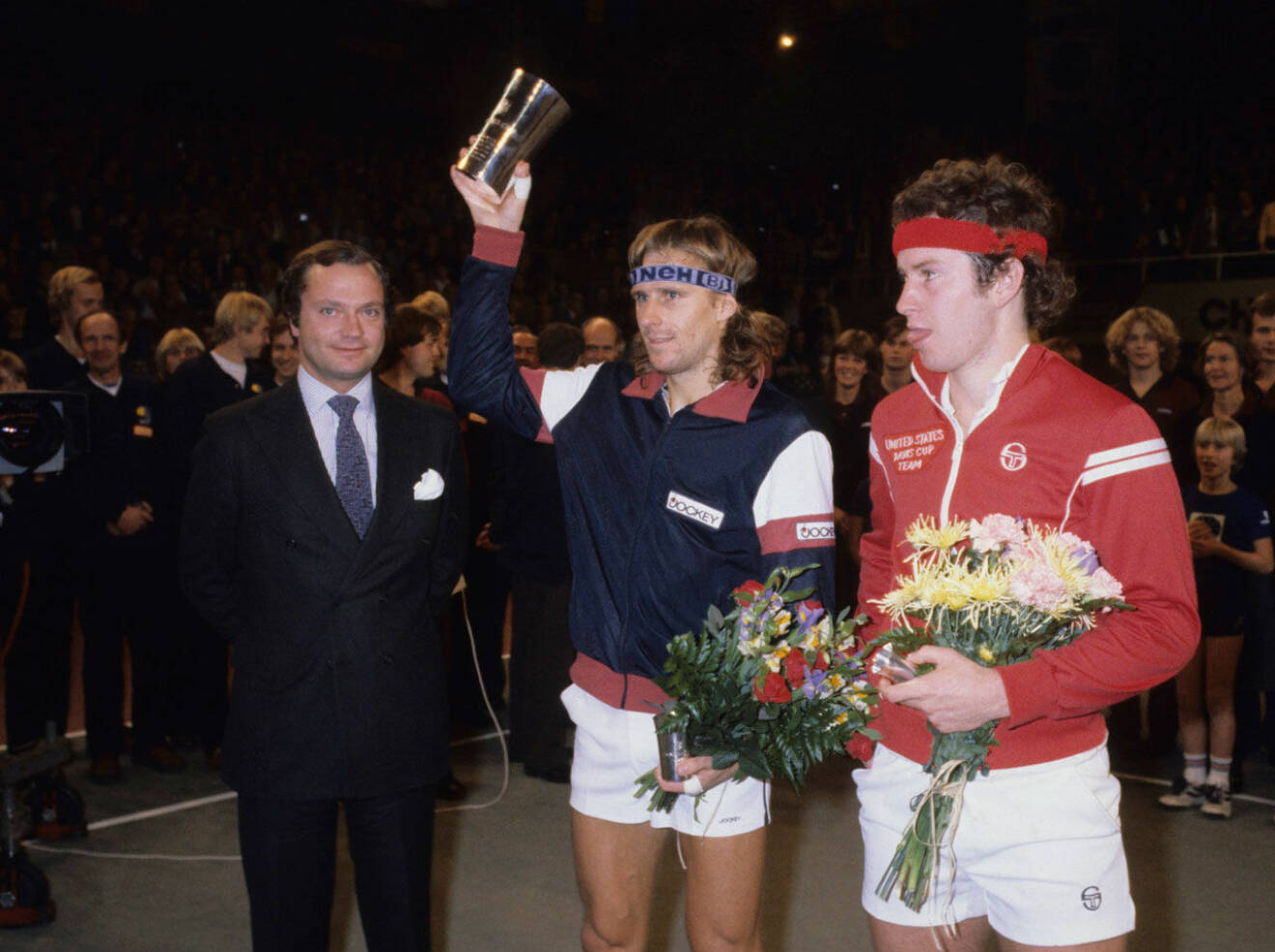 Här är det kungen som ger segerbucklan till en glad Björn Borg. John McEnroe ser inte riktigt lika glad ut.