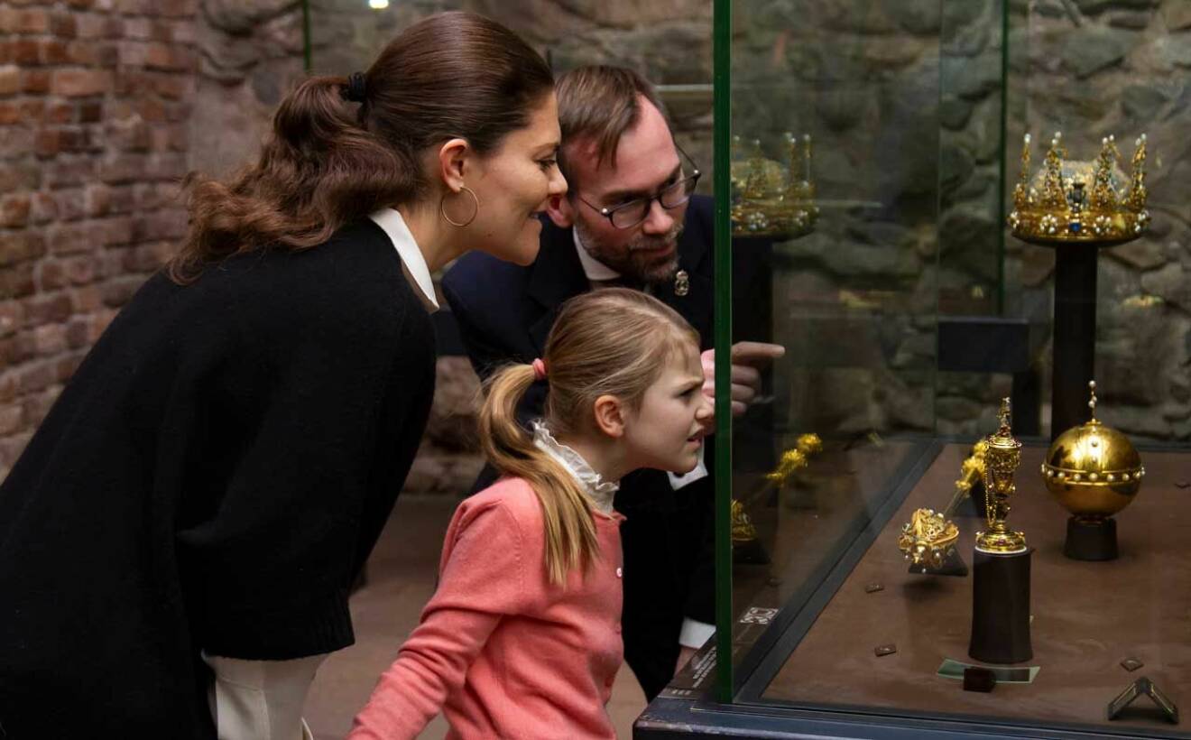 Prinsessan Estelle och kronprinsessan Victoria tittar på riksregalierna. 
