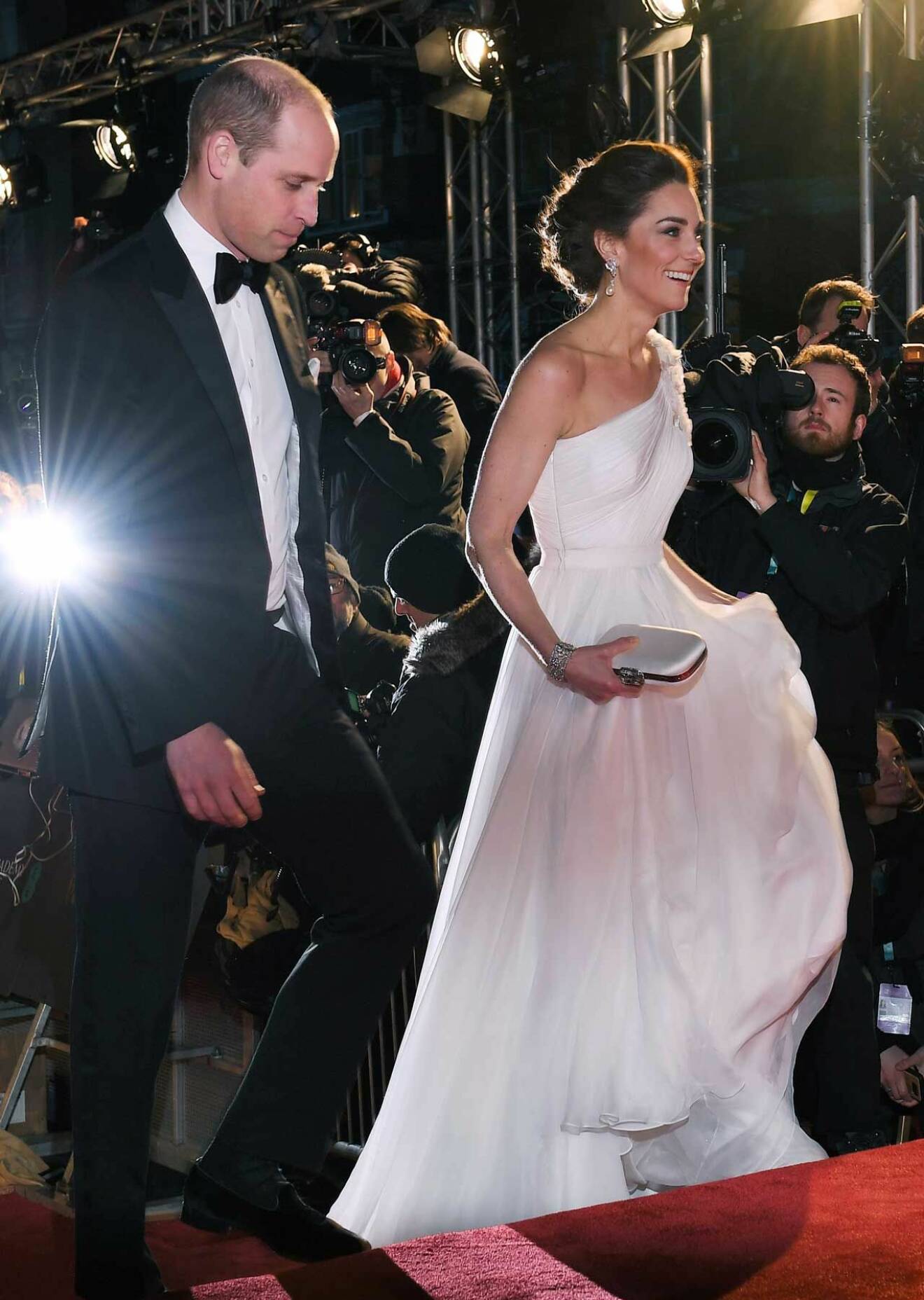 Prins William och hertiginnan Catherine (Kate) på den brittiska filmgalan. Hon i en vit assymetrisk klänning från Alexander McQueen.