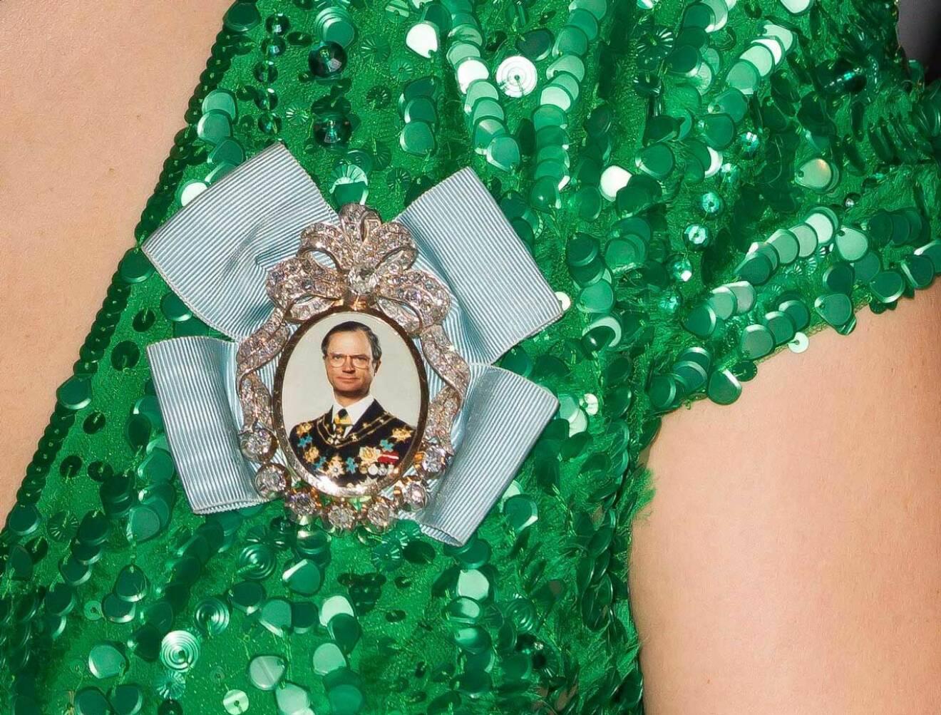 Över kronprinsessan Victorias bröst syns en relativt ung kung Carl Gustaf. 