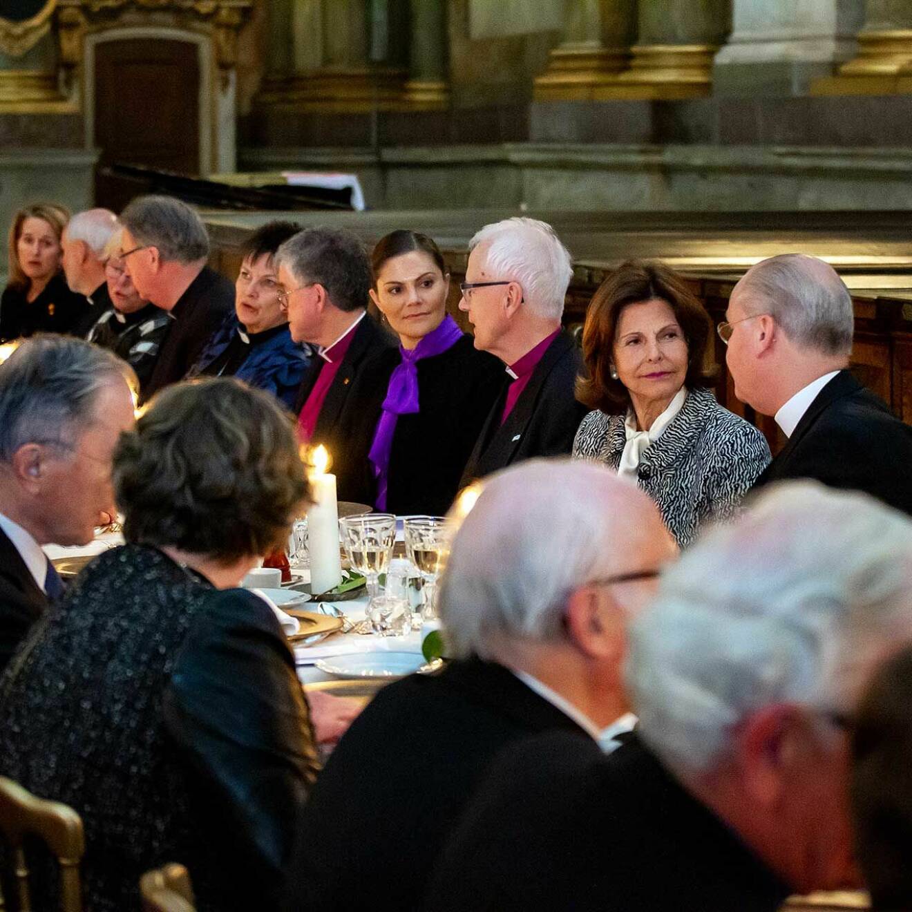 Kronprinsessan Victoria åt middag i Slottskyrkan, klädd i lila knytblus. Bredvid drottning Silvia.