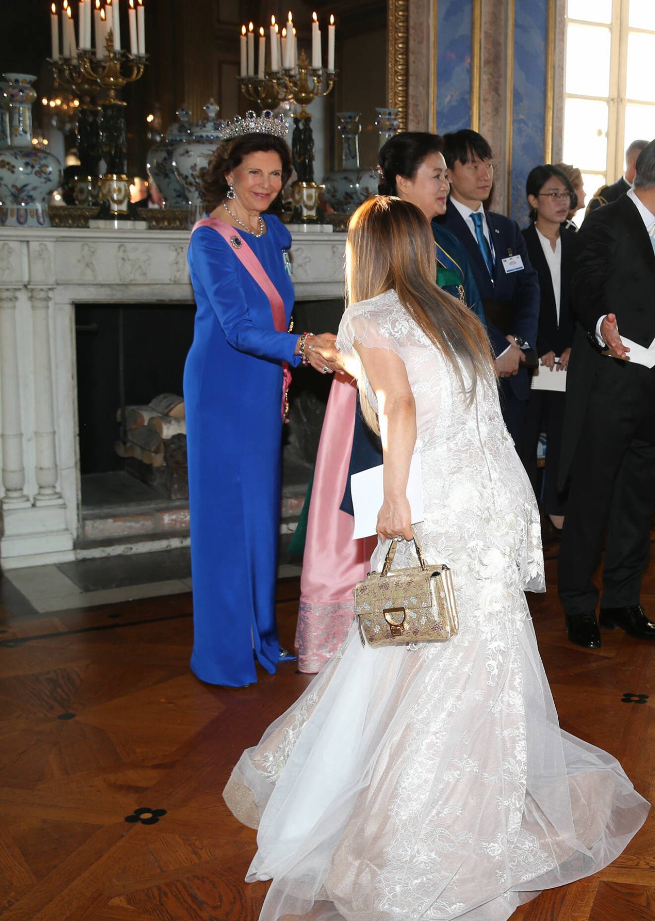 En av gästerna hovniger för drottning Silvia vid galamiddagen på slottet.