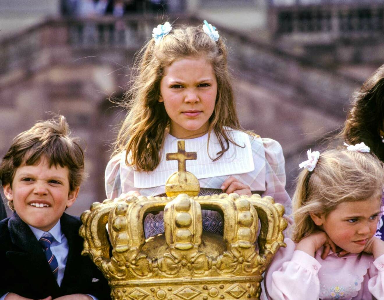 Kronprinsessan Victoria och hennes syskon framför den förgyllda kronan.