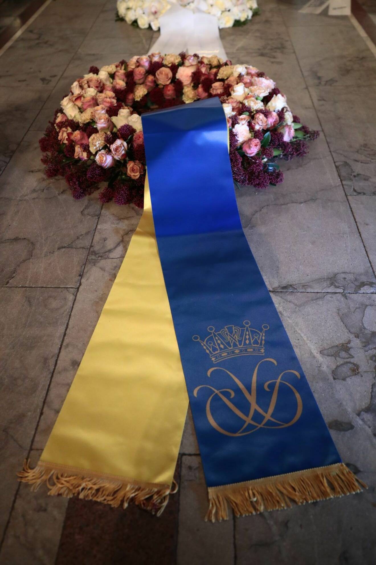 Kronprinsessparets monogram pryder det blågula bandet.