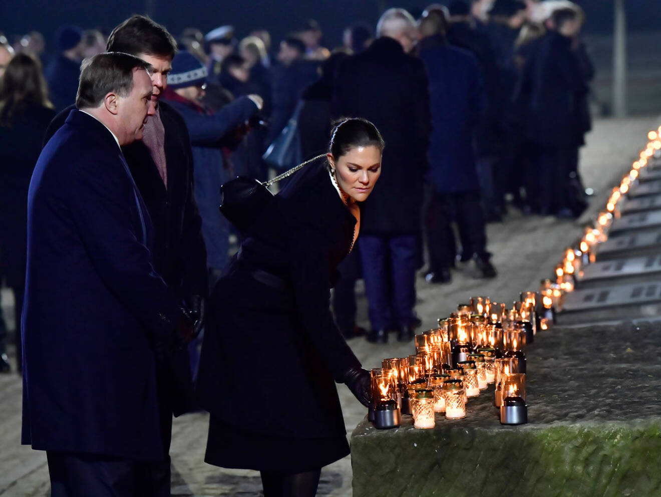 Kronprinsessan Victoria, statsminister Stefan Löfven och talmannen Andreas Norlén tänder ljus vid minneshögtiden i Auschwitz Birkenau.