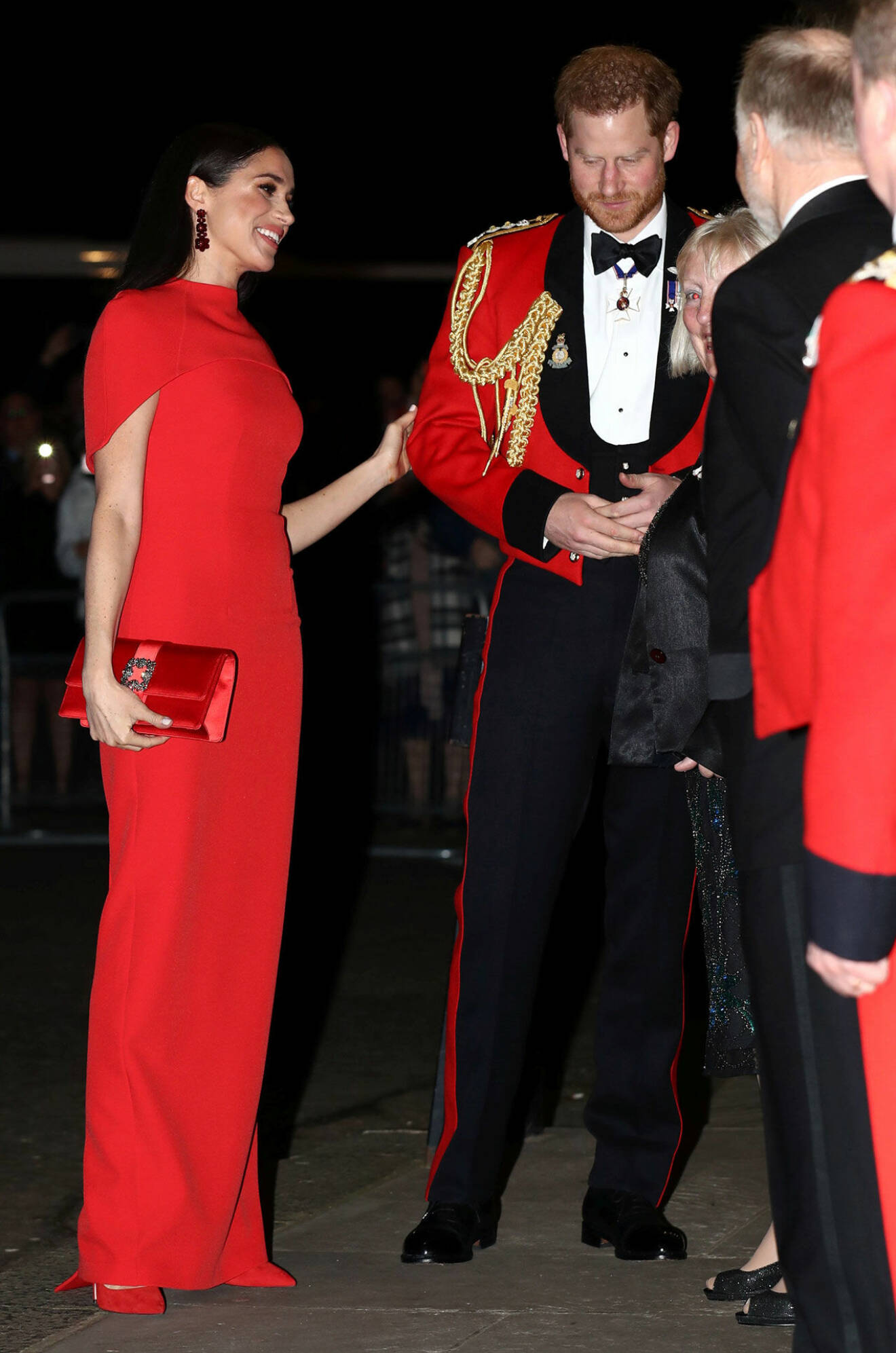 Meghan och prins Harry i rött.