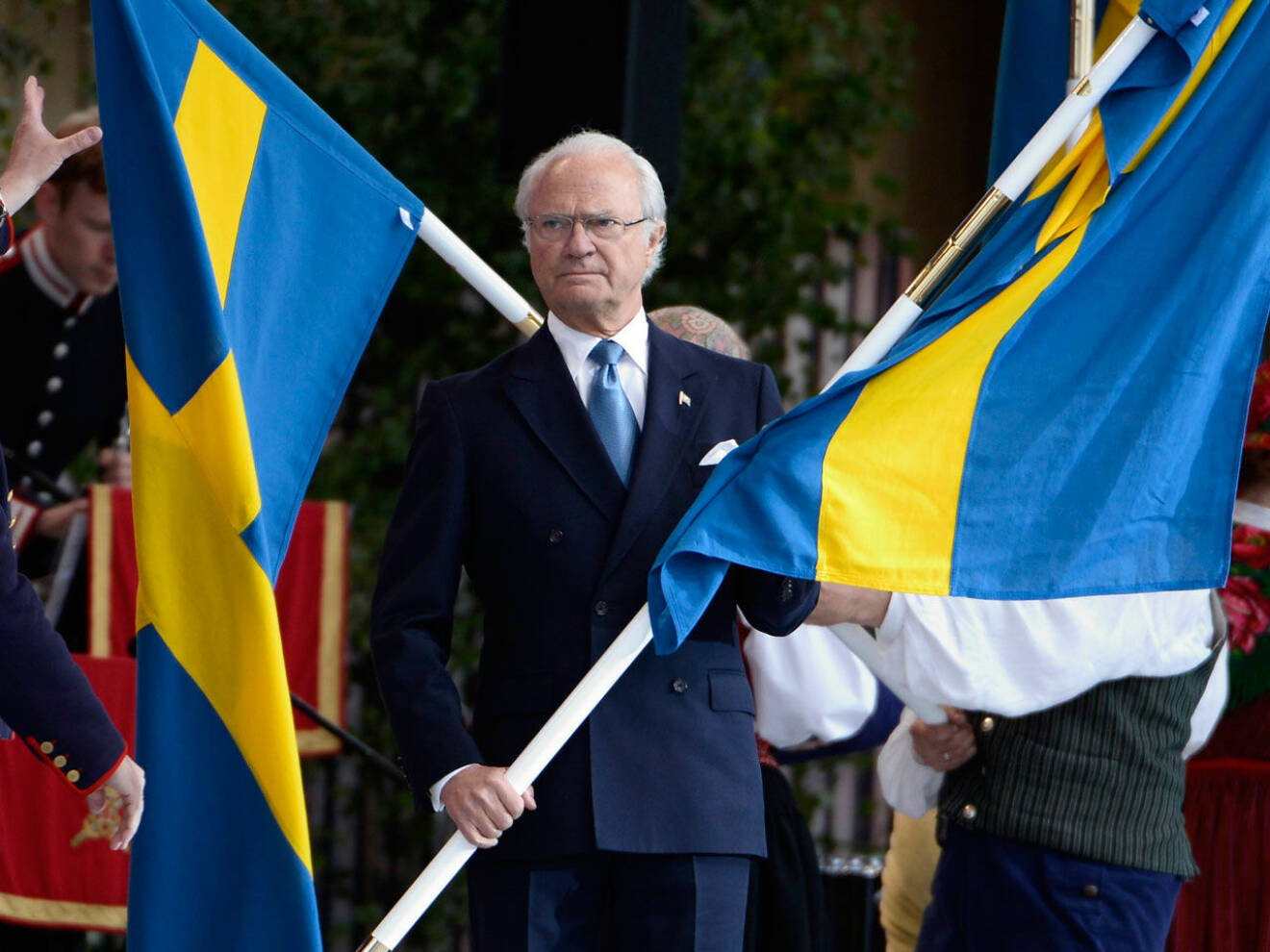 Kungen delar ut svenska flaggor vid nationaldagdagsfirandet på Skansen.