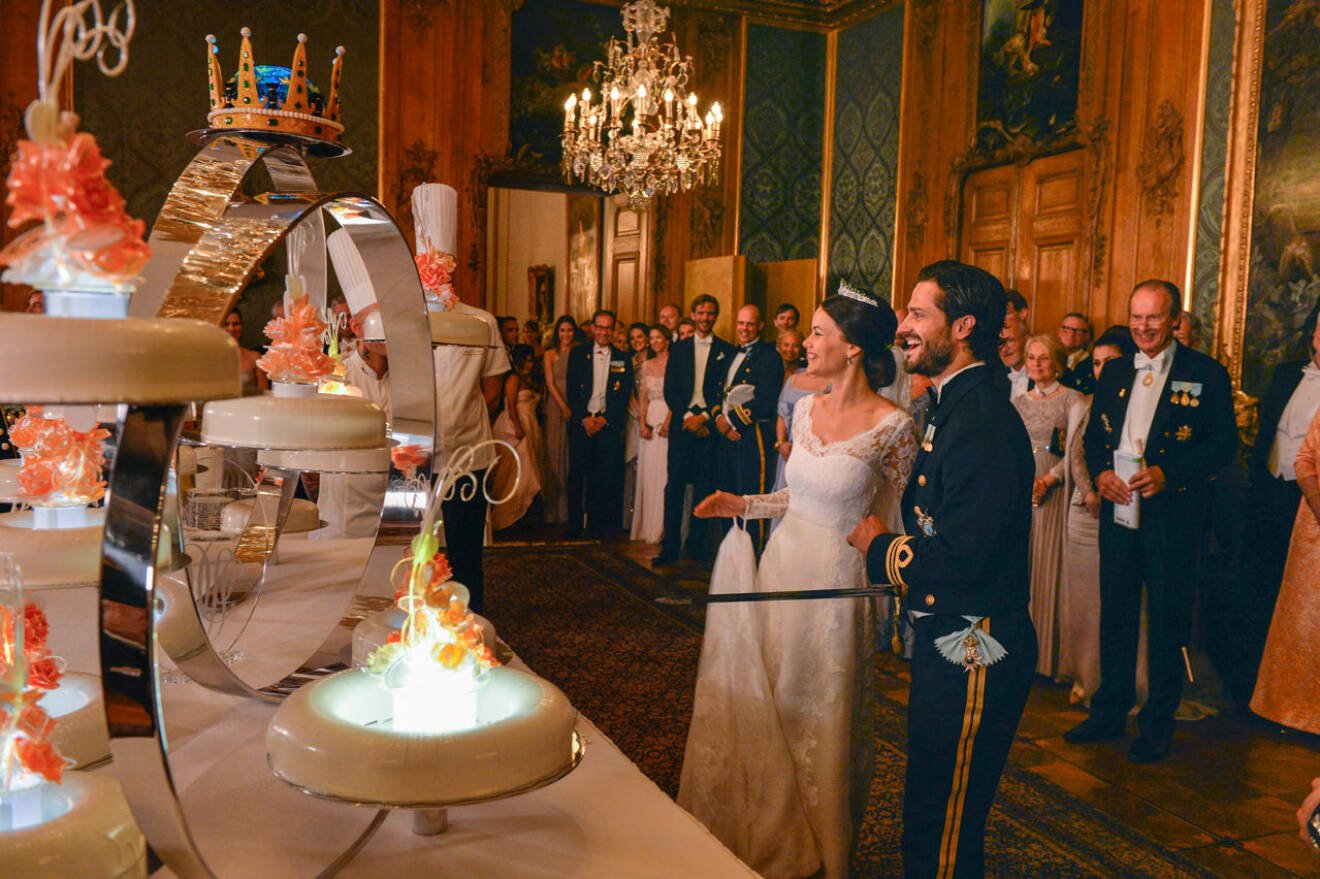 Prins Carl Philip och prinsessan Sofia framför bröllopstårtan