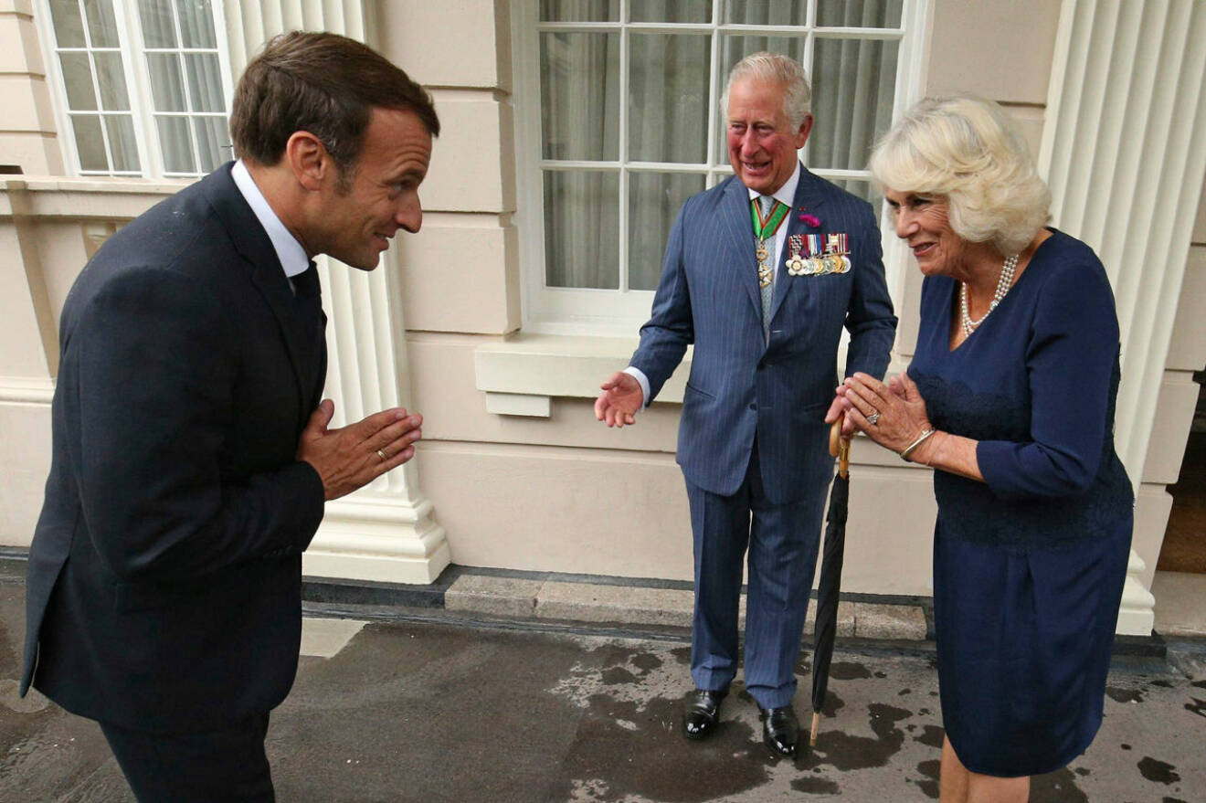 Prins Charles och Camilla hälsar på Frankrikes president Macron.