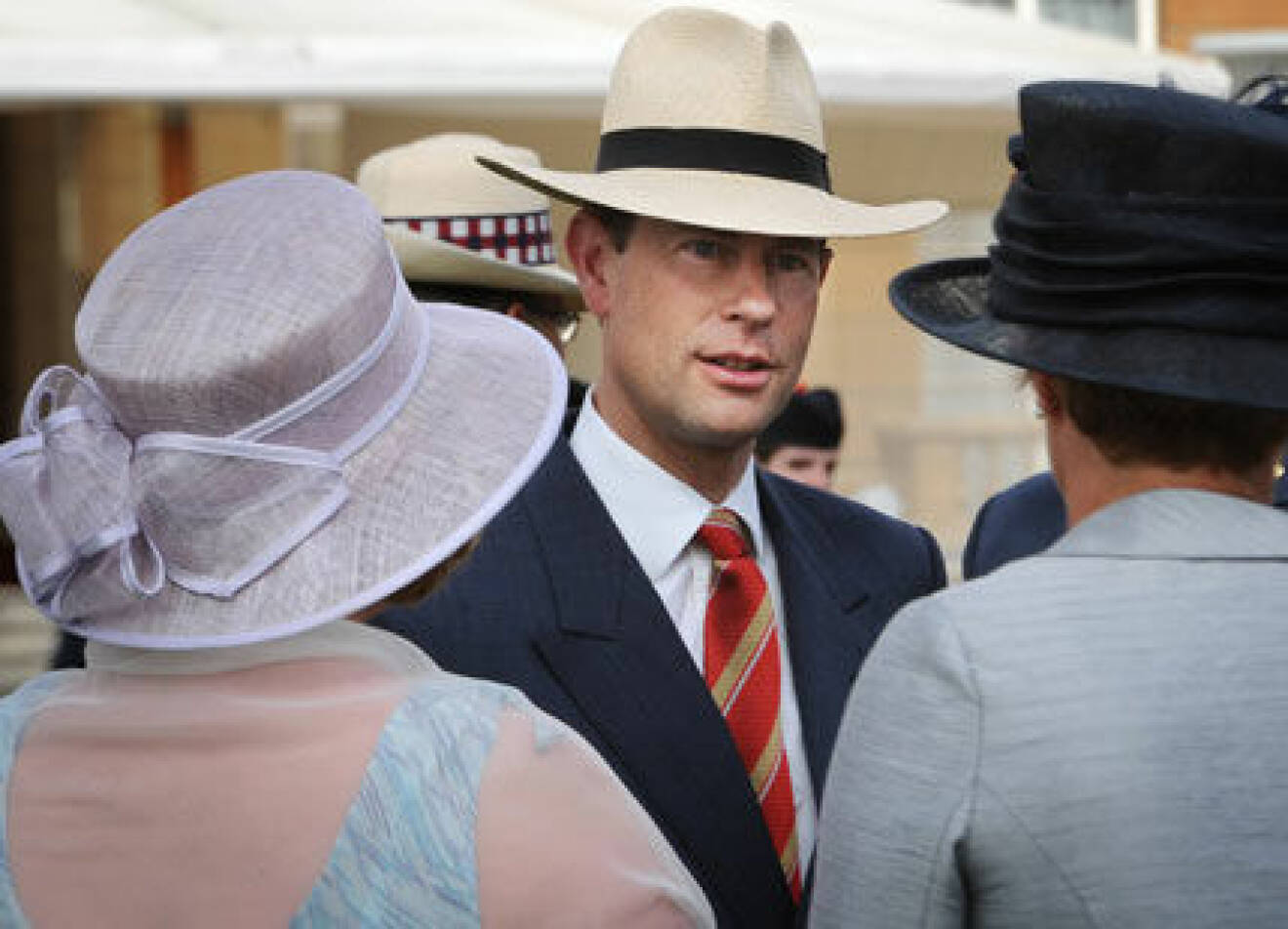 Prins Edward hälsar på damer i hatt.