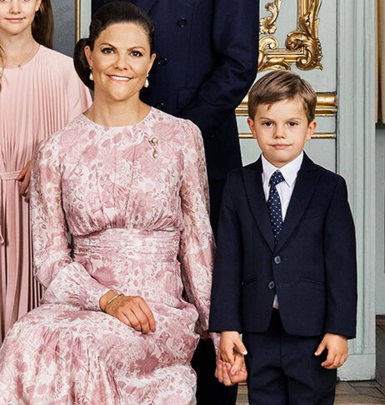 Prins Oscar håller mamma kronprinsessan Victoria i handen på hovets officiella bild