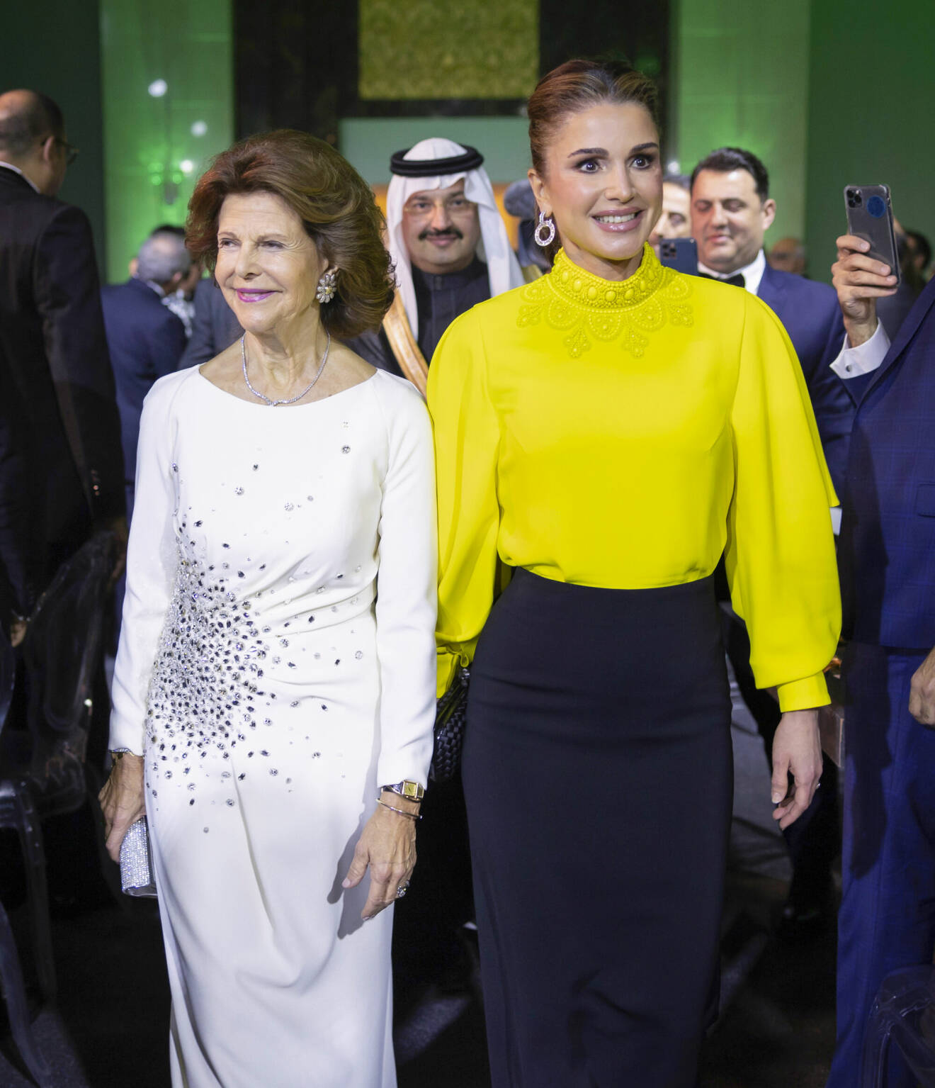 Drottning Silvia i vit aftonklänning från Georg et Arend, drottning Rania i gult och svart
