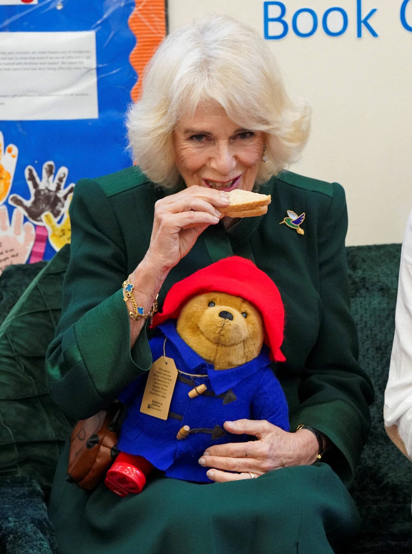 Drottninggemål Camilla äter en marmeladmacka med en Paddington-björn i knät