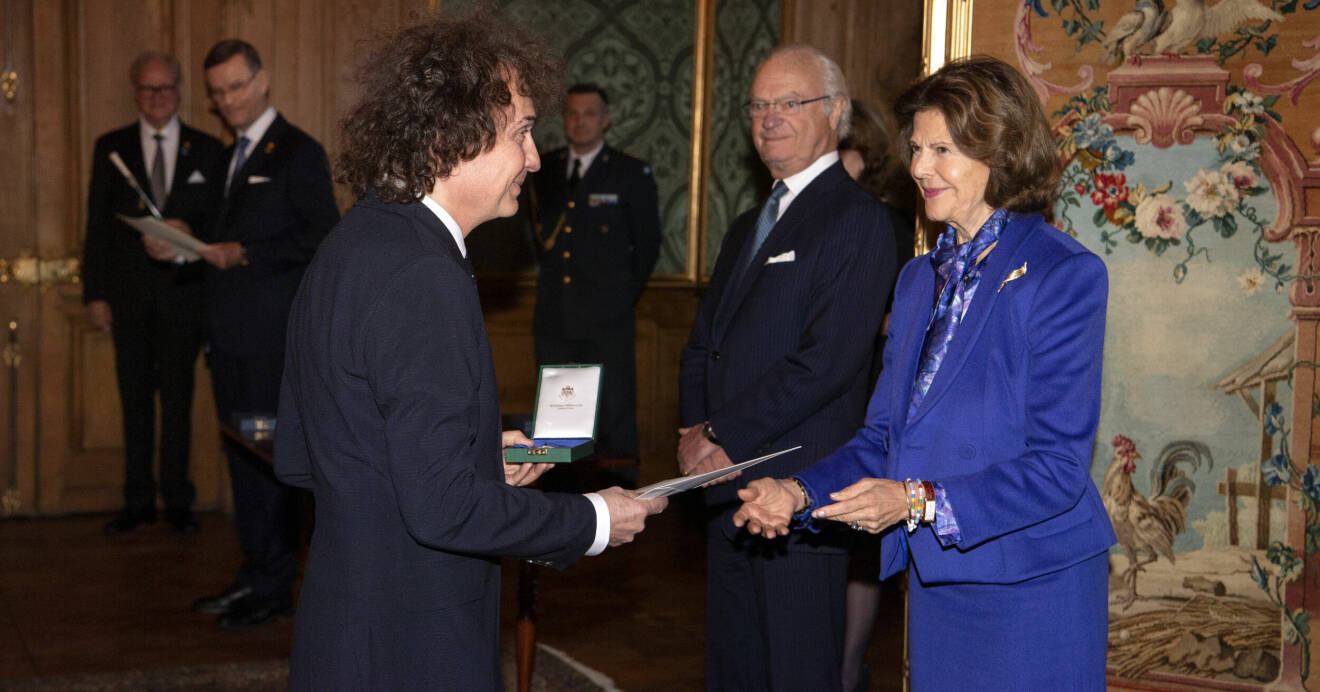 Magnus Uggla tar emot medaljen Litteris et Artibus av kung Carl Gustaf och drottning Silvia under en ceremoni på kungliga slottet i Stockholm