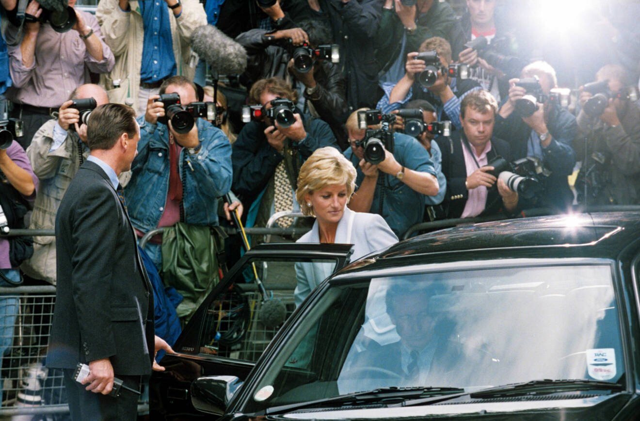 Prinsessan Diana kliver in i en bil omringad av paparazzis