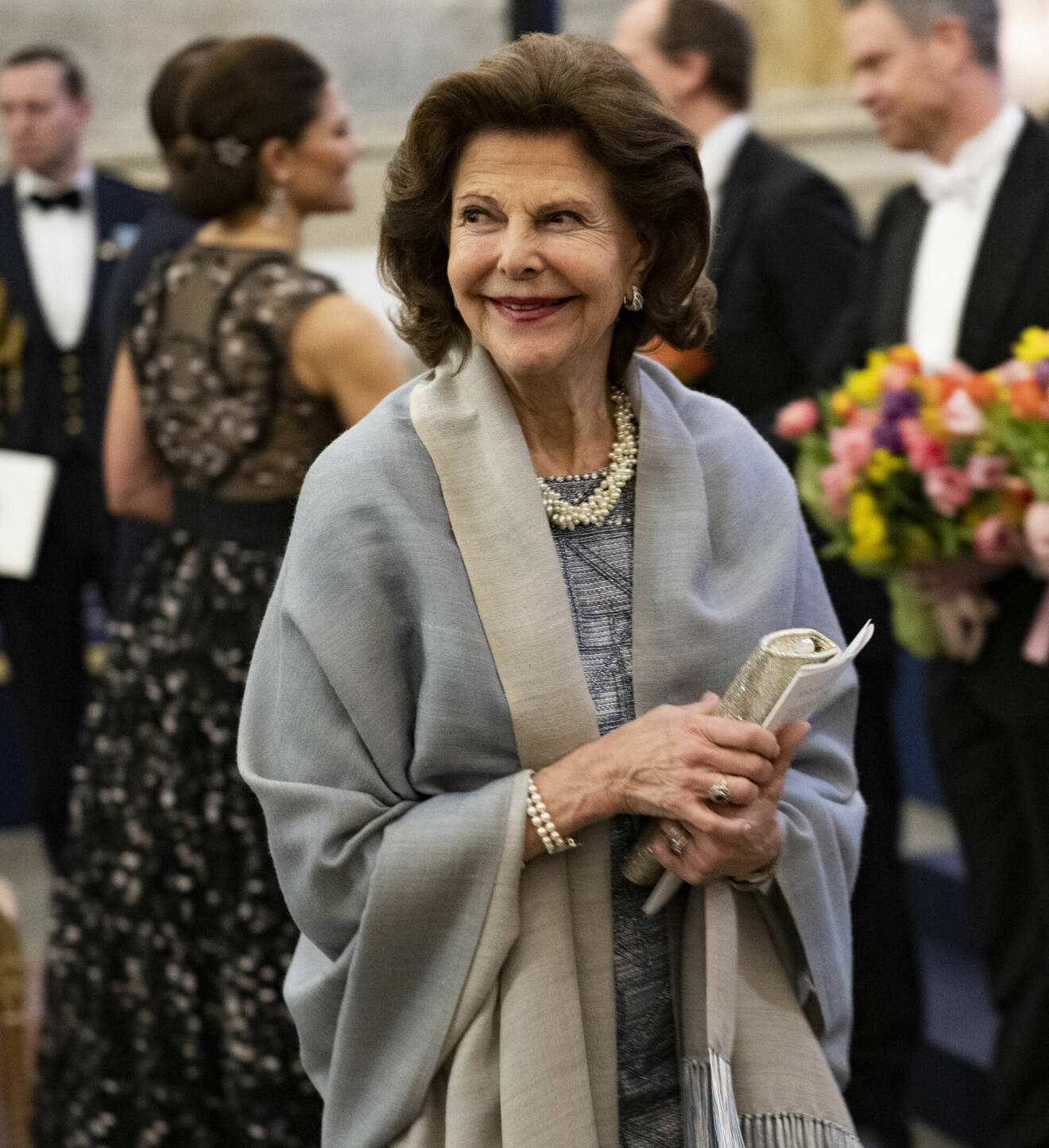 Drottning Silvia i grå paljettklänning och sjal på Sverigemiddagen 2023