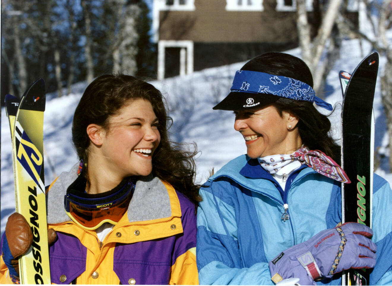 Kronprinsessan Victoria och drottning Silvia tittar på varandra och ler i skidor