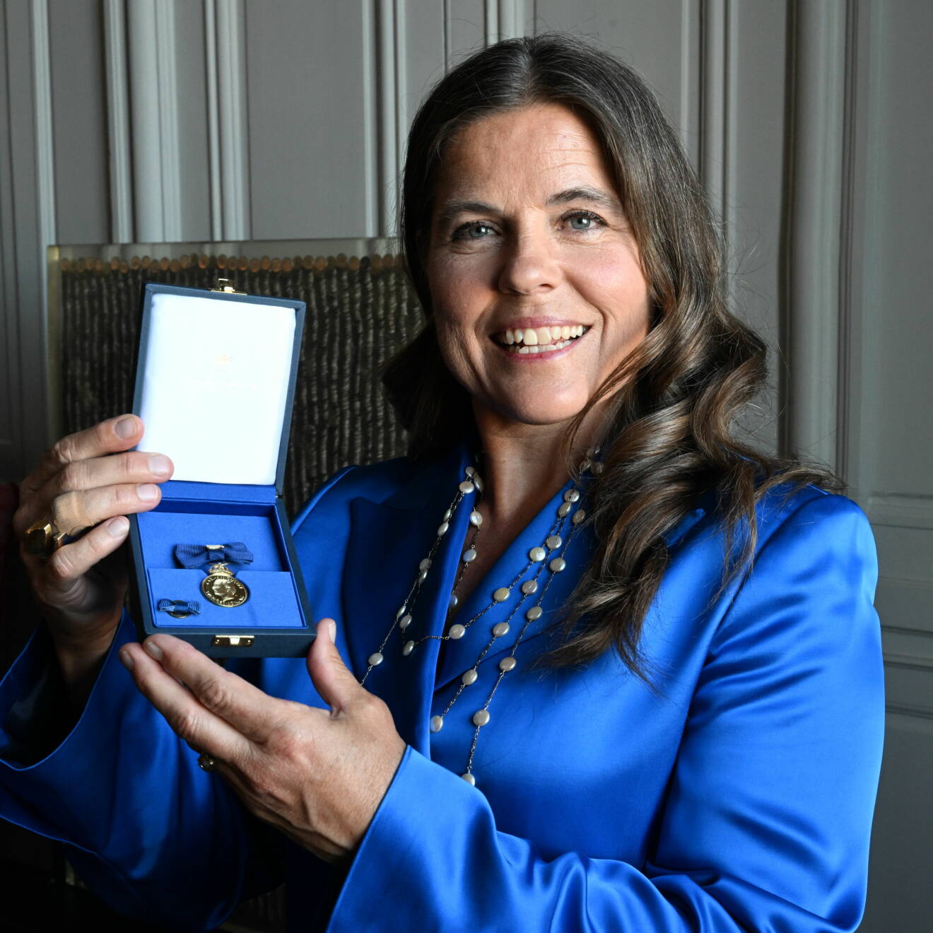 Pernilla Wiberg Bjerke visar medaljen som hon fått av kungen