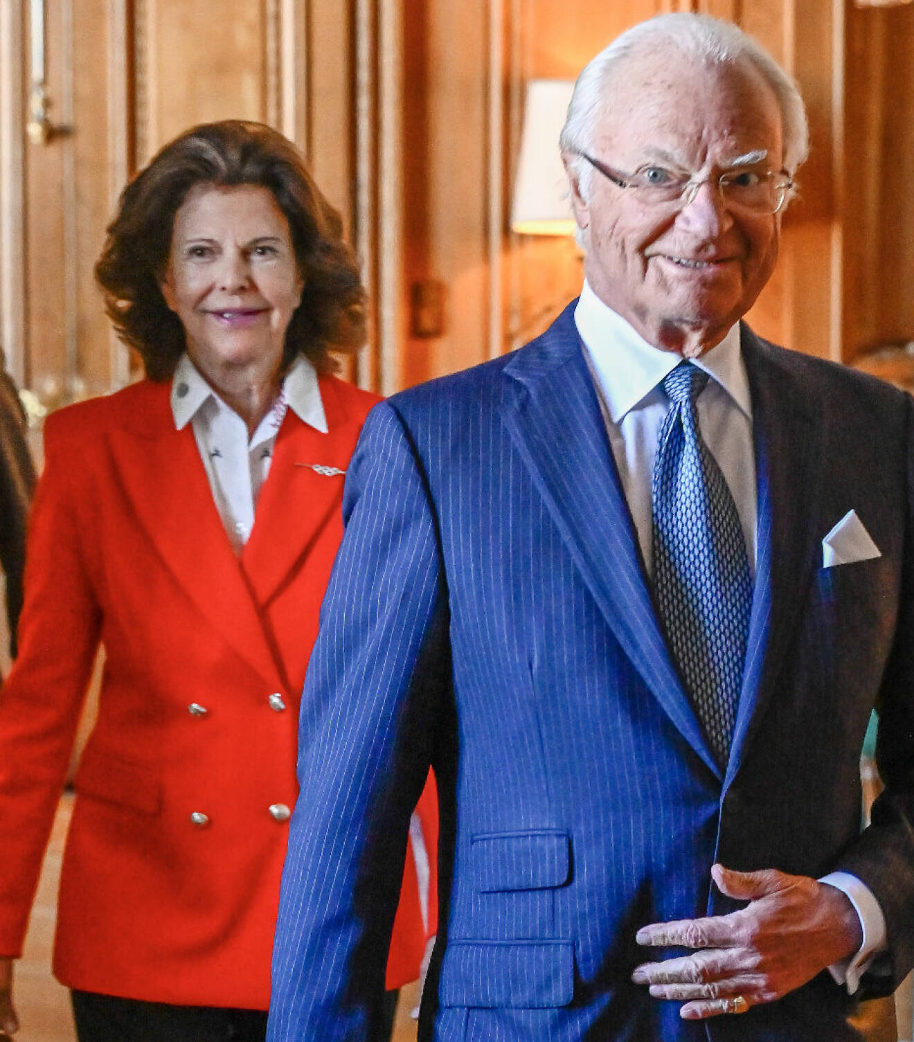 Kungen i blå kostym och drottning Silvia i rött