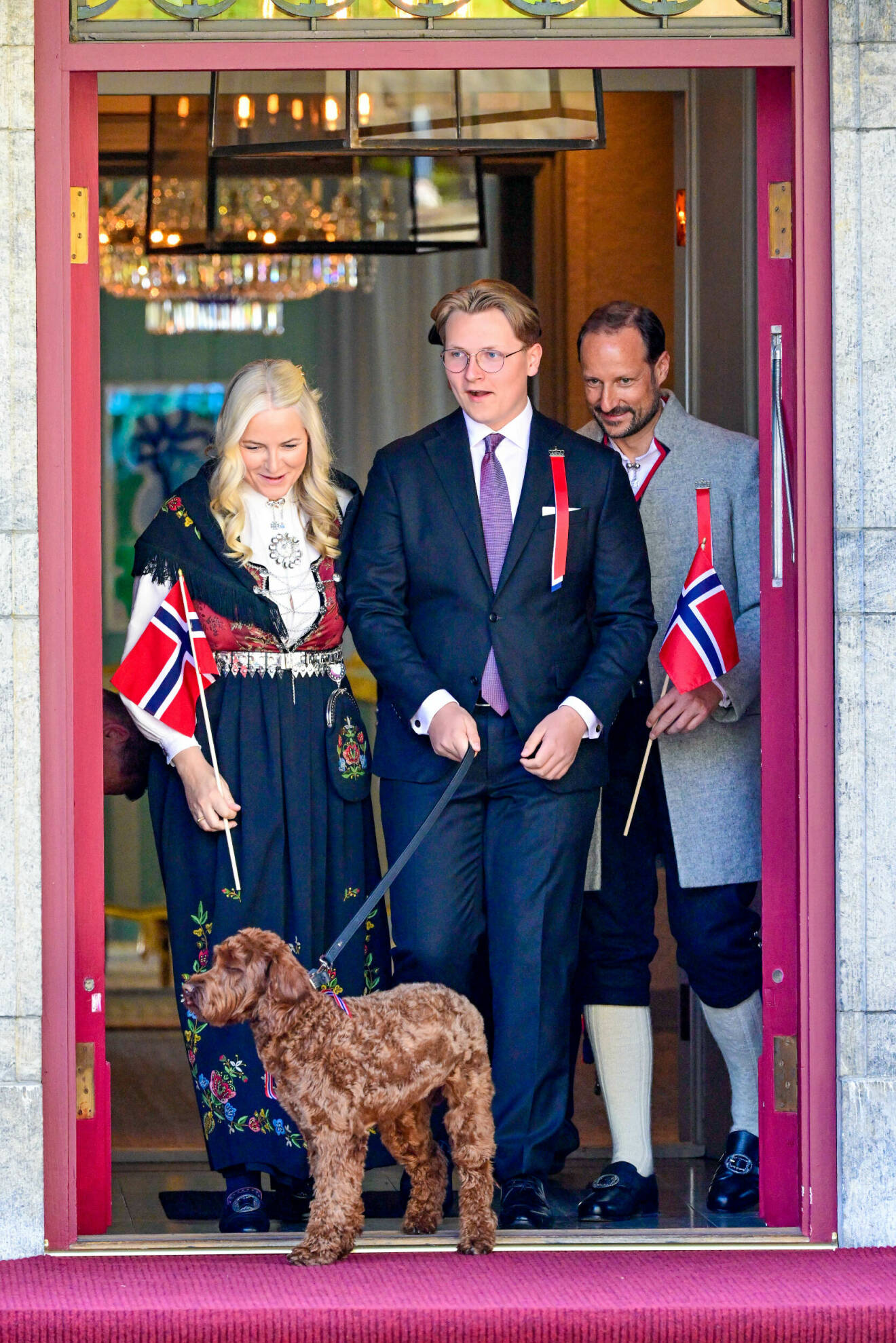 Kronprinsessan Mette-Marit, prins Sverre Magnus och kronprins Haakon med hund Molly Fiskbolle på Skaugum vid nationaldagsfirandet 2023