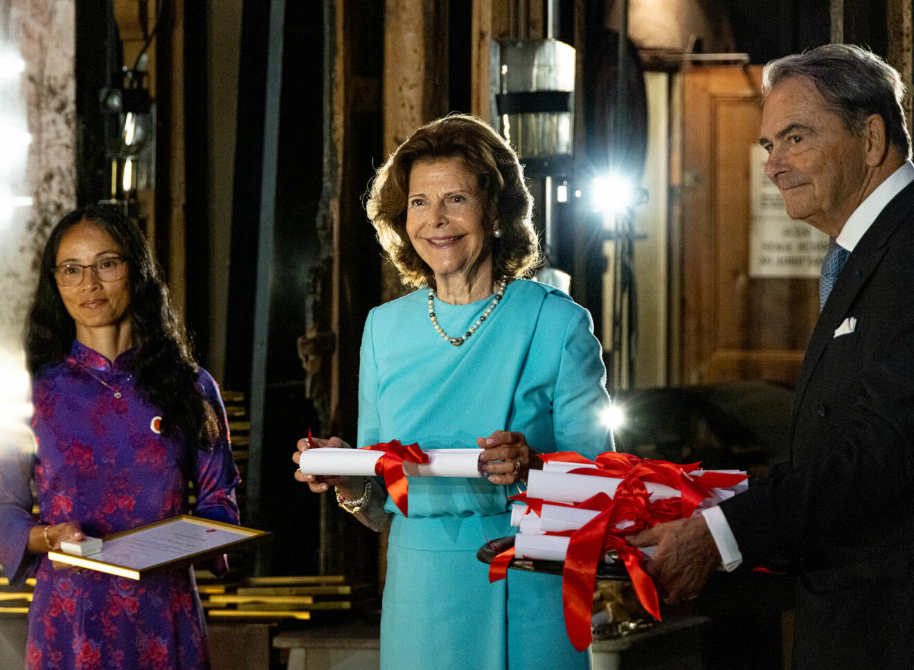 Drottning Silvia vid Silviahemmets diplomeringsceremoni med silviasystern Hoa Hoang och Claes Dinkelspiel