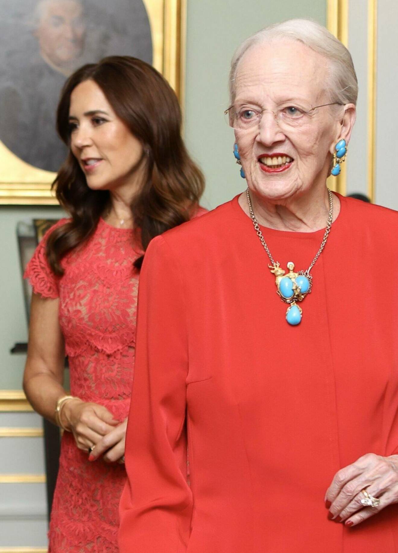 Drottning Margrethe på filmpremiär klädd i rött och med smycken med turkoser