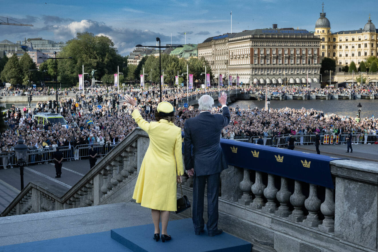 Kungen 50 år på tronen: Kungen och drottning Silvia vinkar under folkfesten i Stockholm