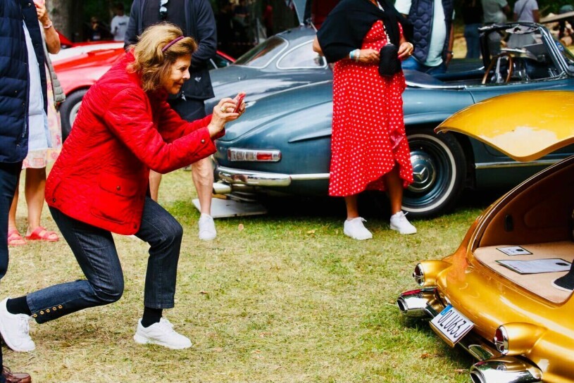 Drottning Silvia i en kunglig balansakt för att fånga motivet på bästa sätt! Drottning Silvia fotar med mobilen
