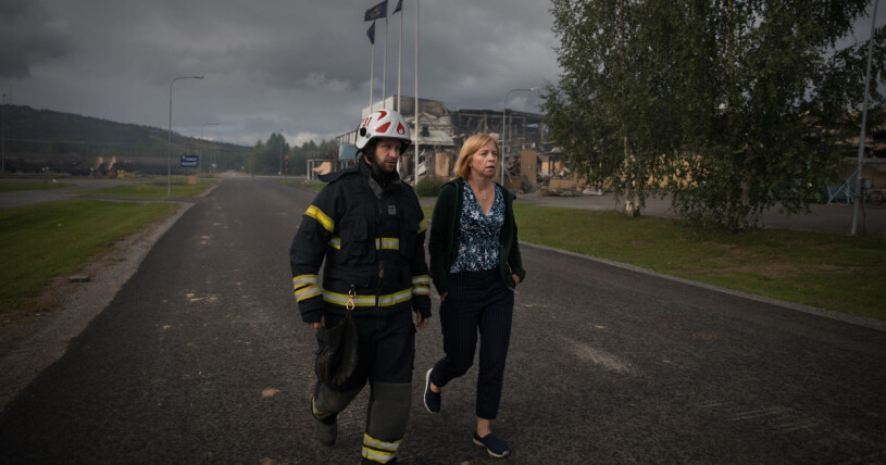 Karin Bodin framför den nedbrunna fabriken i Älvsbyn. Karin Bodin