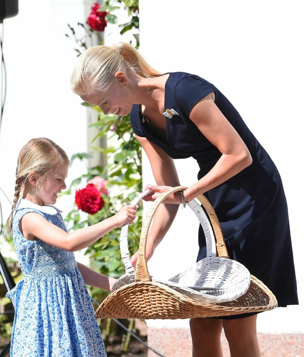 Samma blomsterkorg – men Estelle har vuxit! Hovmarskalk Karolin A. Johansson samlar in blommor på Solliden tillsammans med prinsessan Estelle.