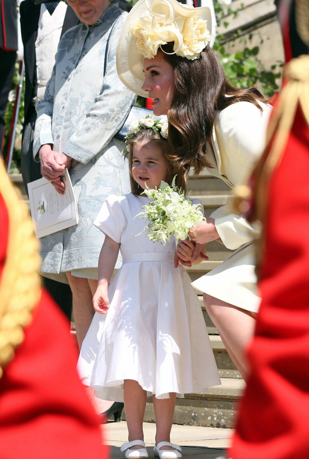 Kate håller masken på Meghans bröllop. Kate och Charlotte på Meghans bröllop.