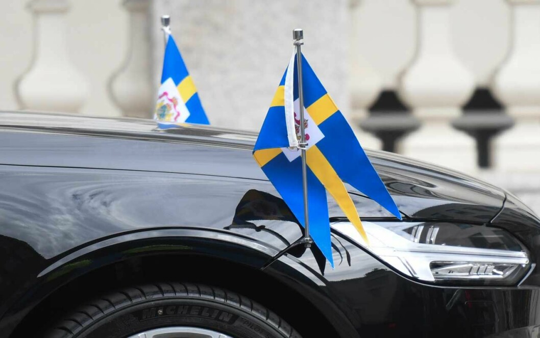 Kungaparets bil. Kungaparets limousin med svenska flaggor på fronten.