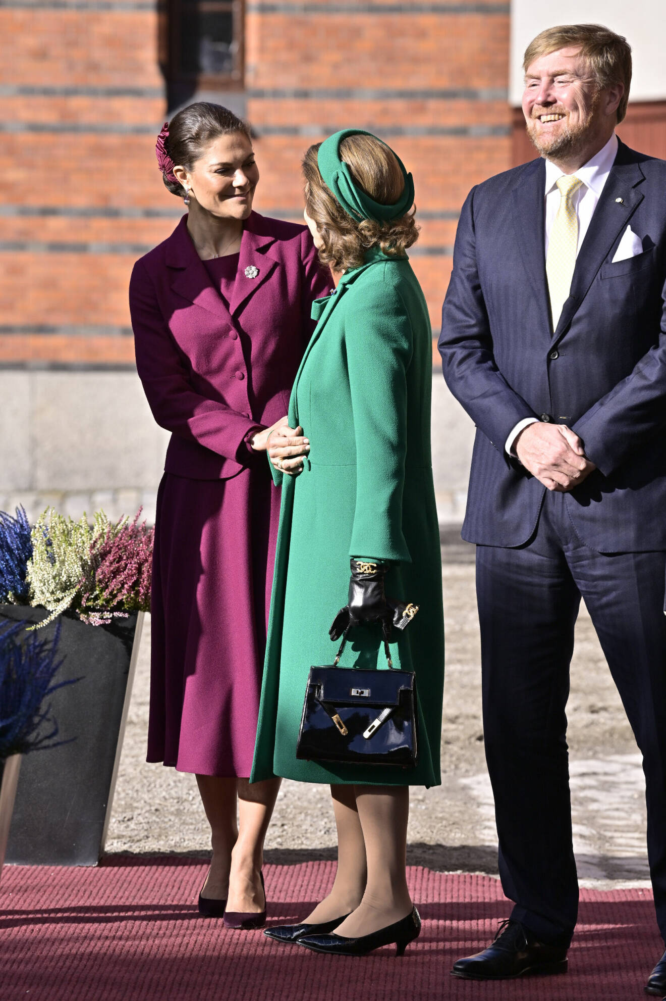 Kronprinsessan Victoria i lila dräkt, och drottning Silvia i grön kappa, med nederländska kung Willem-Alexander
