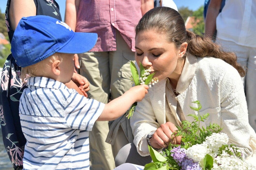 Åh så ljuvliga liljekonvaljer! En liten pojke ville att kronprinsessan Victoria skulle dofta på blommorna först. Kronprinsessan Victoria doftar på liljekonvaljer som en liten pojke sträcker fram.