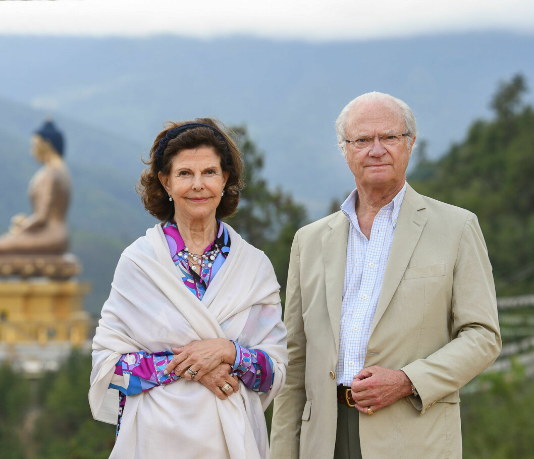 Kungen skickar sina kondoleanser i egenskap av Sveriges statschef. Kungaparet i Asien, med en Buddhastaty i bakgrunden.