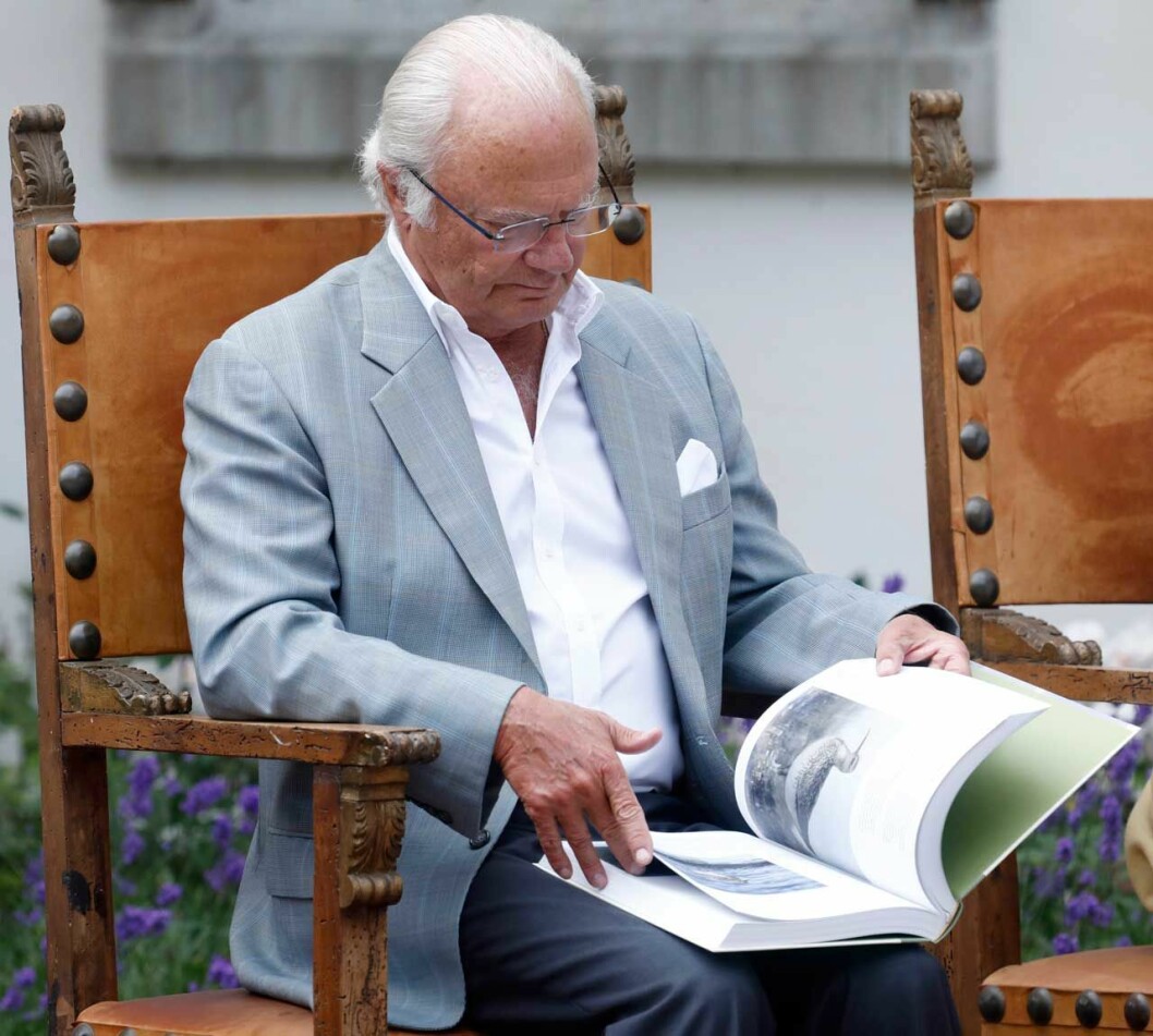 Kungen sommarklädd, bläddrar i en bok på Solliden. Årets Ölänning 2019.