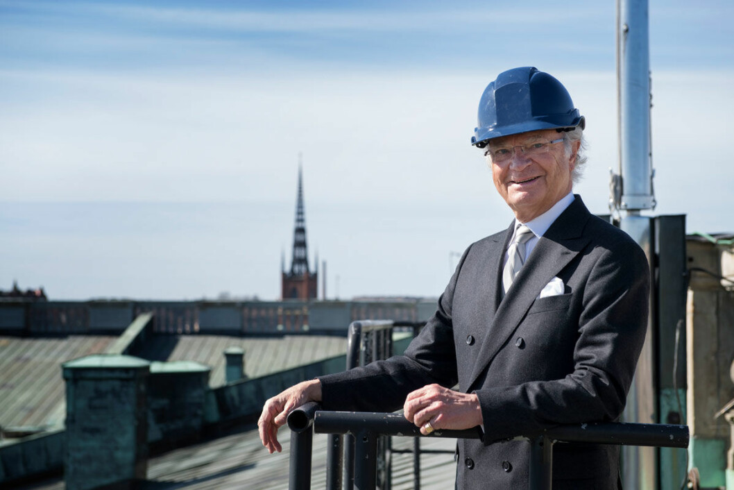 Kungen i dubbelknäppt kostym och blå hjälm.
