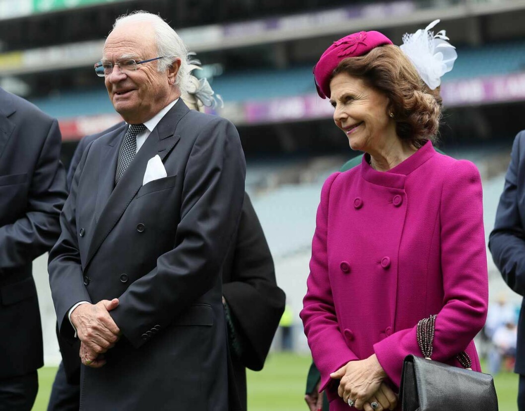 Kungen (som brukar säga att han inte har något bollsinne) stod bredvid och hejade på sin fru. Kung Carl Gustaf och drottning Silvia på en idrottsarena i Dublin.