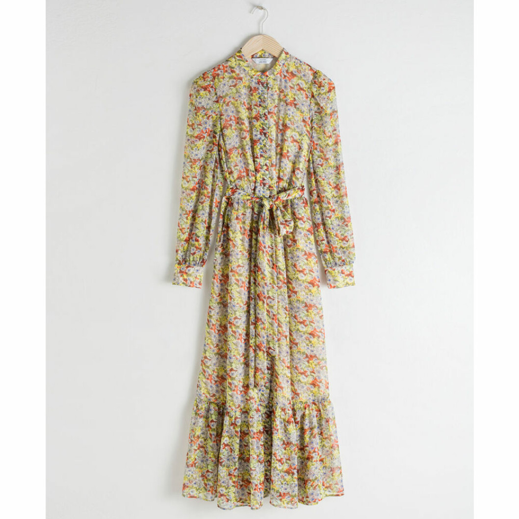 Lång klänning med små blommor och knytdetalj i midjan från Twist & Tango. <a href="https://track.adtraction.com/t/t?a=1279077969&as=1267646502&t=2&tk=1&url=https://www.stories.com/en_sek/clothing/dresses/printed-dresses/product.floral-ruffled-maxi-dress-floral.0712567002.html" target="_blank" rel="noopener">Här kan du läsa mer och köpa den</a>. Lång klänning med små blommor i rött, grönt och gult med volangdetaljer