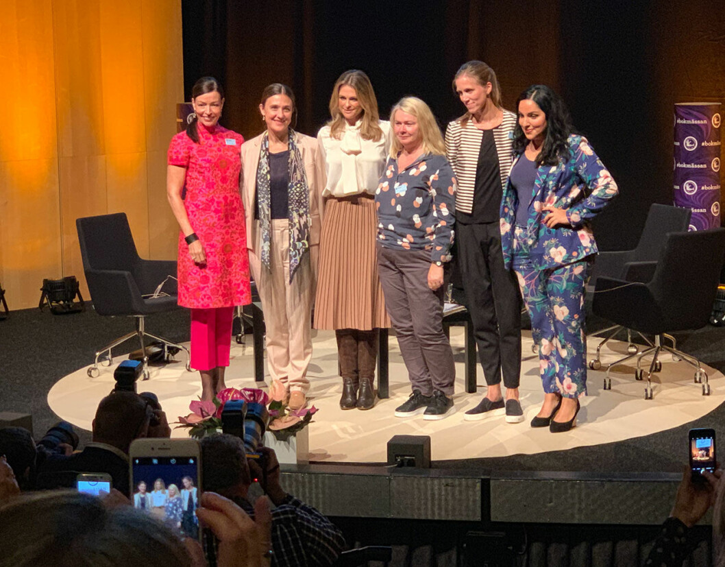 Prinsessan Madeleine med resten av bokteamet: Anna Norlén, Childhood-chefen Paula Guillet de Monthoux, författaren Marie Oskarsson, förläggaren Ulrika Caperius samt Tara Moshizi. Prinsessan Madeleine på Bokmässan 2019 med Anna Norlén, Childhood-chefen Paula Guillet de Monthoux, författaren Marie Oskarsson, förläggaren Ulrika Caperius samt Tara Moshizi.