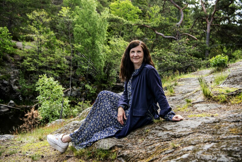 Märta slår sig ner på en klipphäll med fantastisk utsikt över vattnet. Miljöpartiets språkrör Märta Stenevi