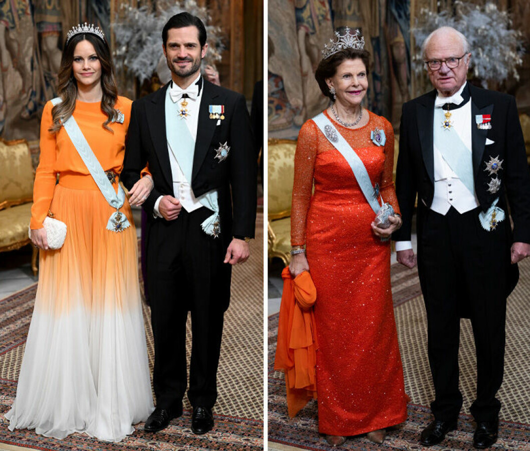 Prinsessan Sofia i en orange klänning bredvid prins Carl Philip, och drottning Silvia i en orange klänning bredvid kung Carl Gustaf