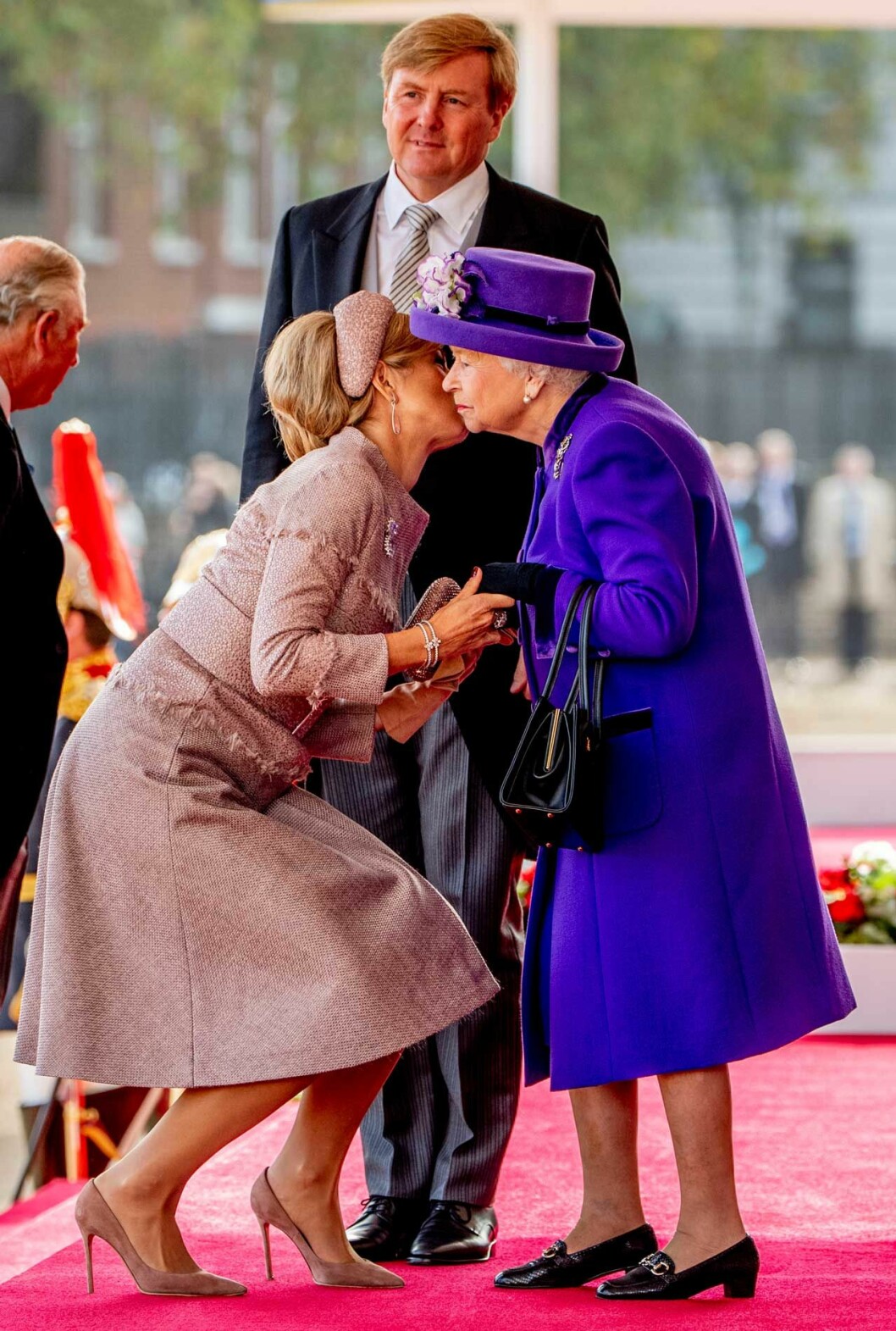 Drottning Elizabeth såg själv ut att tycka att det var lite komiskt… Långa drottning Máxima kindpussar korta drottning Elizabeth.