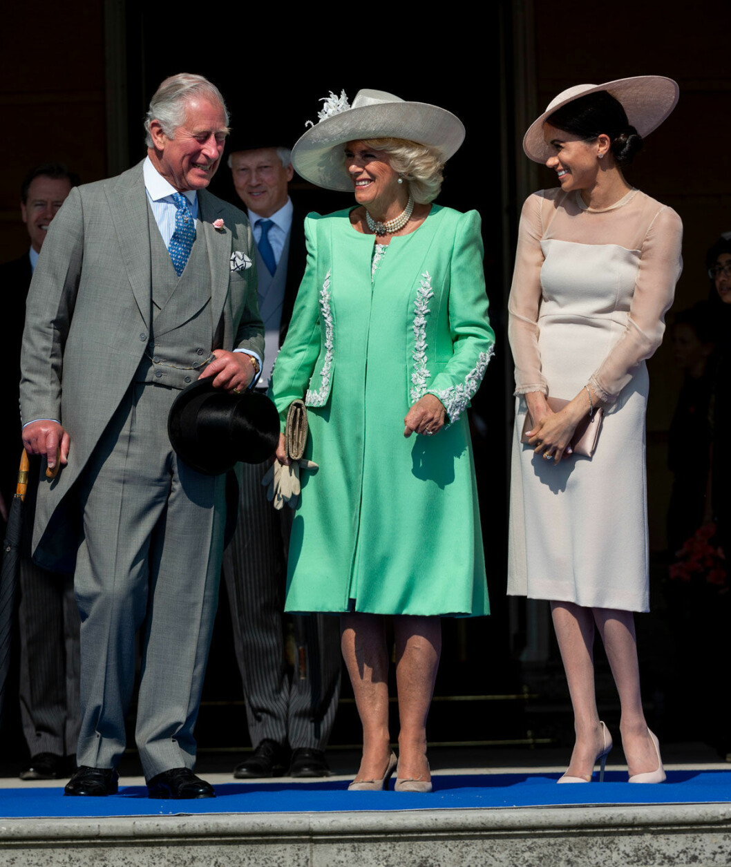 Charles och Camilla skrattar med Meghan.