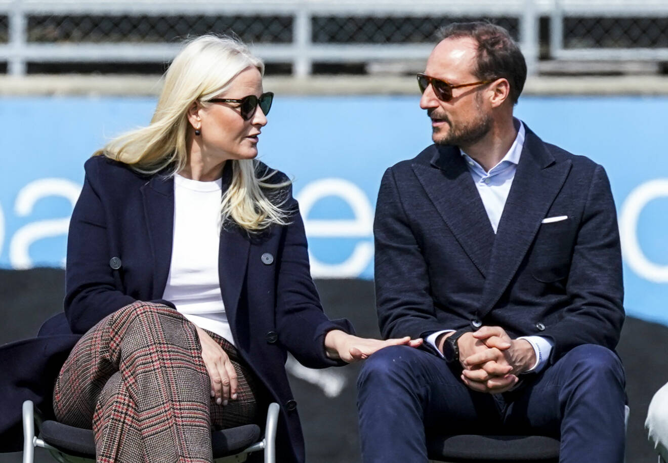 Mette-Marit och Haakon i solglasögon som tittar på varandra